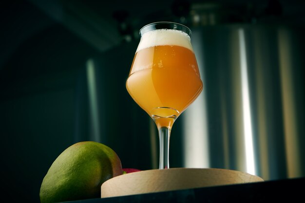 Bière artisanale fraîche de blé et de mangue dans un verre classique avec des collations