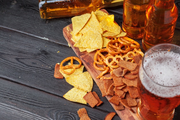 Bière blonde et des collations sur une table en bois