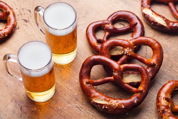 Photo bière et bretzels salés sur fond de table en bois gros plan