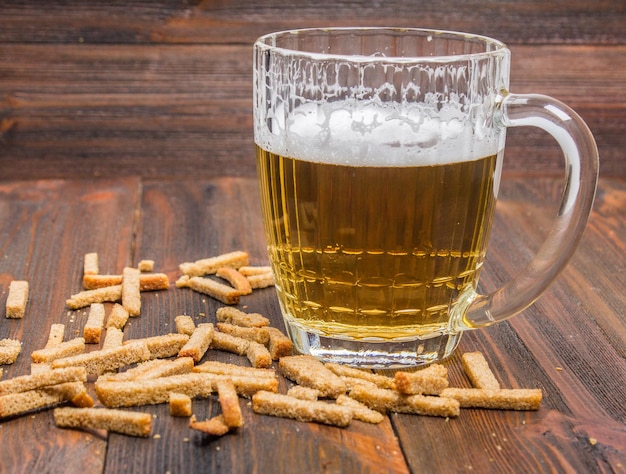 Bière avec des croûtons sur fond de bois