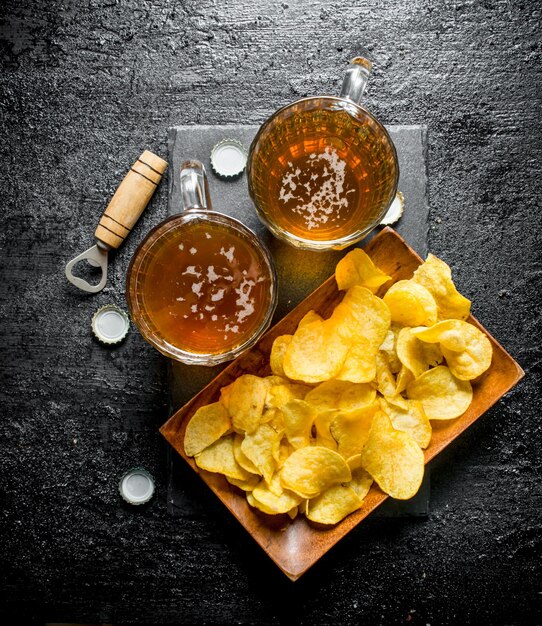 Bière dans des tasses et des frites sur une assiette