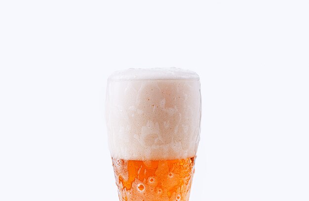 La bière est versée dans un verre sur fond blanc