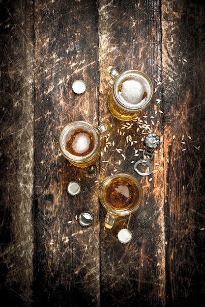 Photo bière fraîche dans un verre avec des bouchons et un décapsuleur