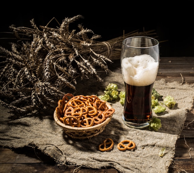 Bière glasse au blé et au houblon, corbeille de bretzels