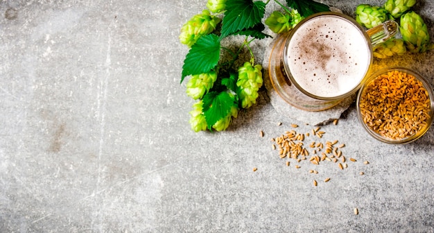 Bière, houblon vert et malt sur une surface en pierre. Vue de dessus