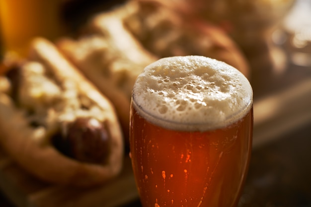 Bière IPA en mug close up avec tête mousseuse servie avec bratwursts