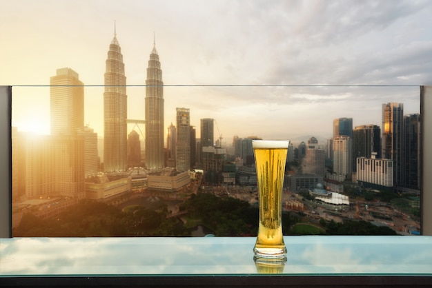 Bière et mousse de bière sur la table dans le bar sur le toit avec Kuala Lumpur, Malaisie.