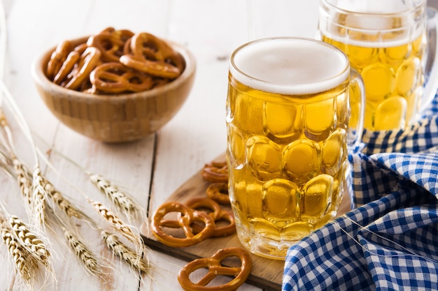 Bière Oktoberfest et bretzel sur table en bois blanc