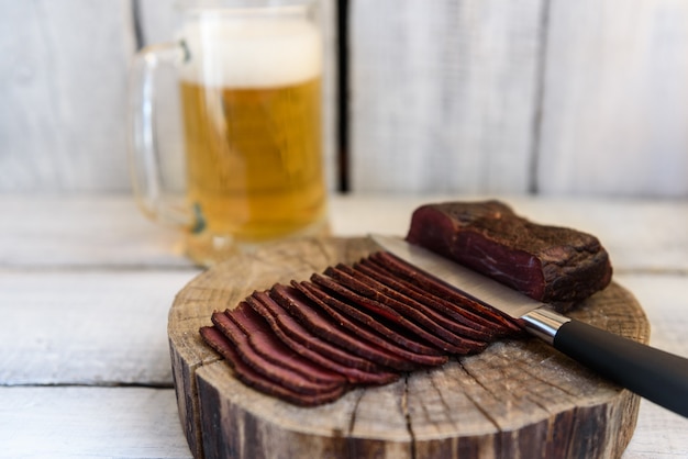 Bière pastrami dans un couteau en verre sur une table en bois