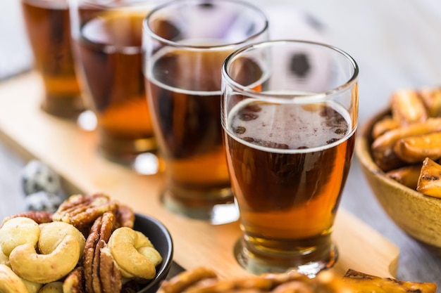 Bière pression et collations salées sur la table pour une fête de football.