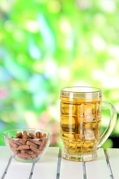 Bière en verre et croûtons sur table sur fond de nature