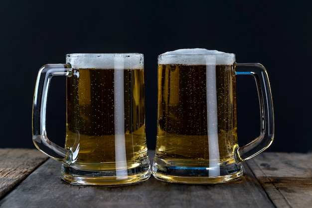 Bière en verre sur la table en bois et fond noir