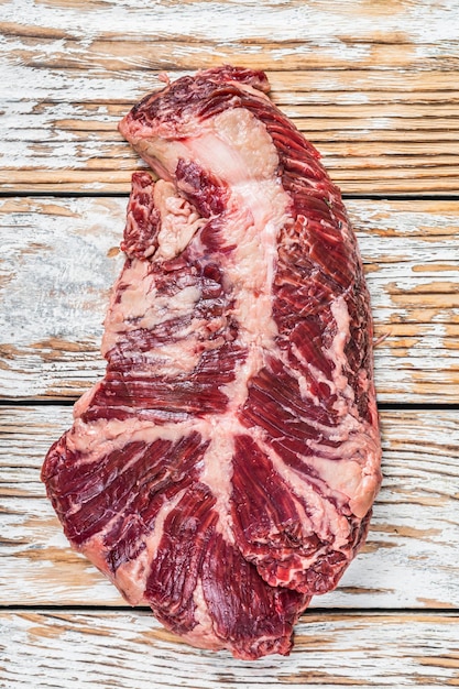 Bifteck au choix du boucher Onglet suspendu Viande de bœuf tendre sur une planche à découper. Fond en bois blanc. Vue de dessus.