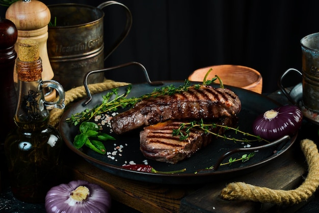 Bifteck de faux-filet grillé herbes et épices sur une table sombre Vue de dessus Espace libre pour votre texte