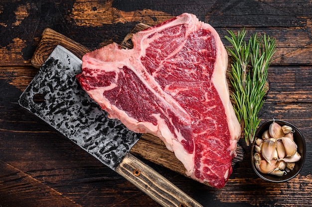 Bifteck de viande de bœuf T-bone italien aux herbes sur une planche à découper en bois