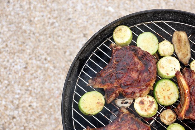Photo biftecks et légumes savoureux faisant cuire sur le gril de barbecue dehors