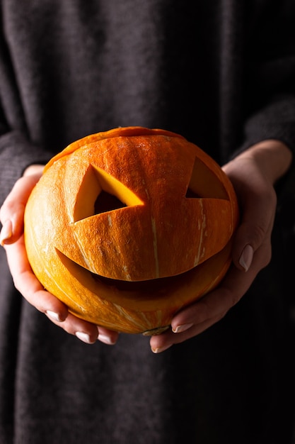 Big pampkin Haloween dans les mains de la femme