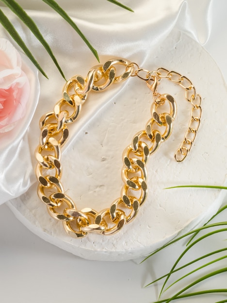 Bijouterie de mode - un grand bracelet de chaîne d'or sur un support blanc