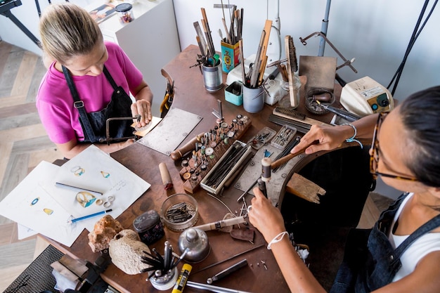 Photo bijoutier enseignant et étudiant fabriquent des bijoux en atelier