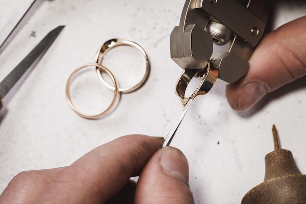 Bijoutier fixe des pierres dans une bague en or