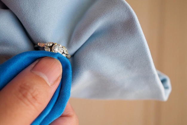 Bijoutier polissage à la main et nettoyage de bague en diamant de bijoux avec tissu en microfibre