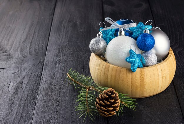 Bijoux de Noël dans un bol sur une surface en bois