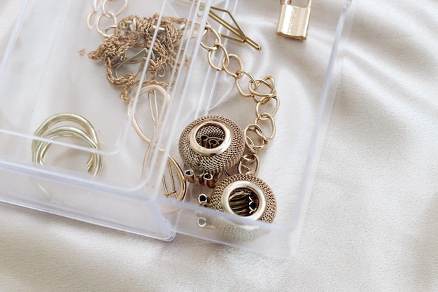 Photo bijoux en or boucles d'oreilles bracelets dans un organisateur transparent