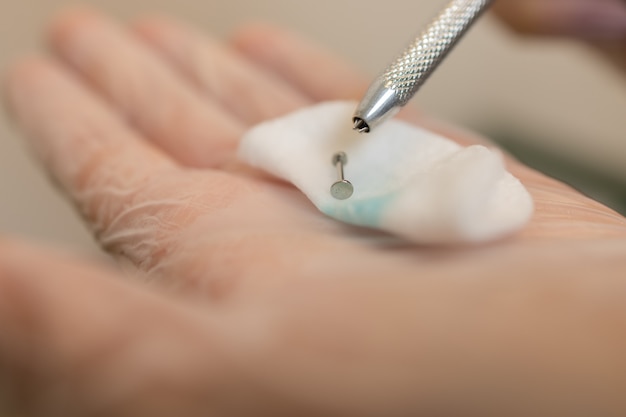 Bijoux d'oreille, piercing à la main avec un gant jetable.