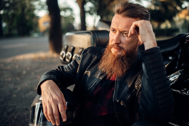 Biker assis sur le sol contre son hachoir