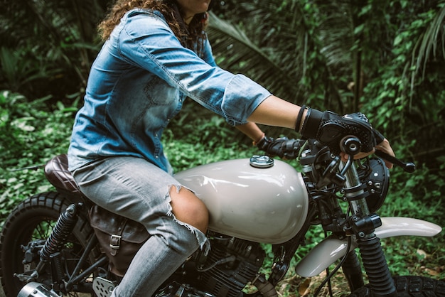 Biker femme conduisant une moto de café racer