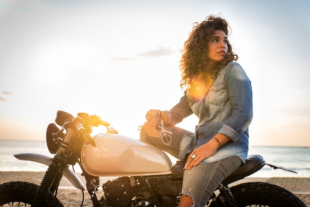 Biker femme conduisant une moto de café racer