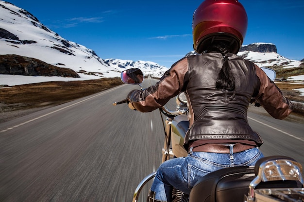 Biker girl chevauche une route de montagne en Norvège. Vue à la première personne.