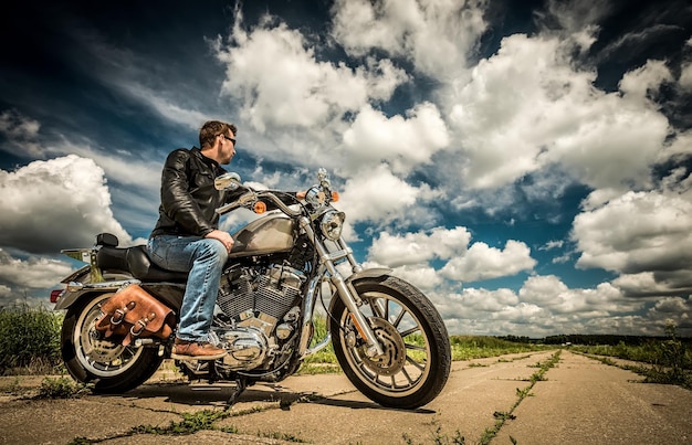 Biker en lunettes de soleil et veste en cuir sur la route