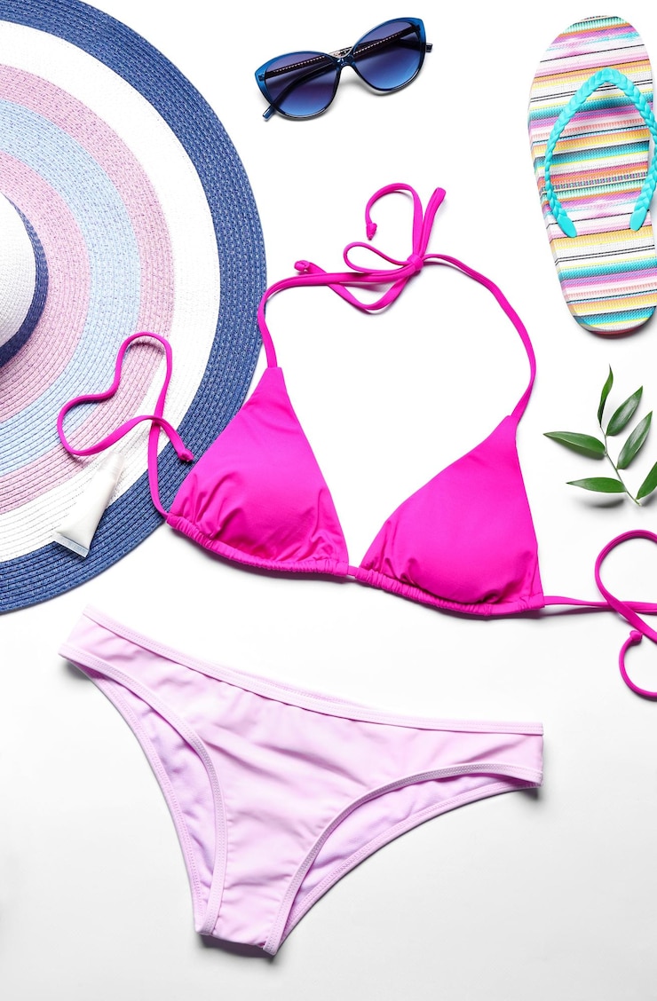 Photo bikini coloré et accessoires de plage sur fond blanc