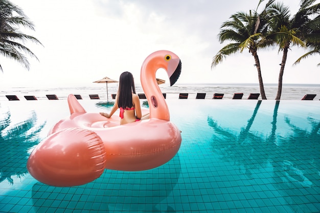 Bikini femme détente sur le flotteur de la piscine