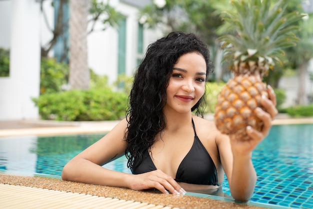 Bikini jeune femme montrant ananas fruits ananas woman smiling sain et joyeux Mixedrace Asian Caucasian model avec ananas