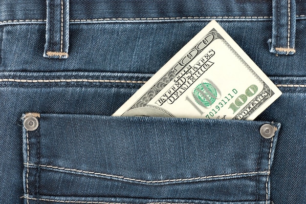 Un billet de cent dollars dans la poche arrière d'un pantalon en jean