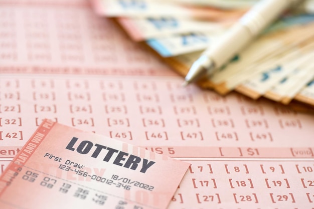 Un billet de loterie et un reçu de jeu sur la table avec un stylo et des billets en euros de l'Union européenne