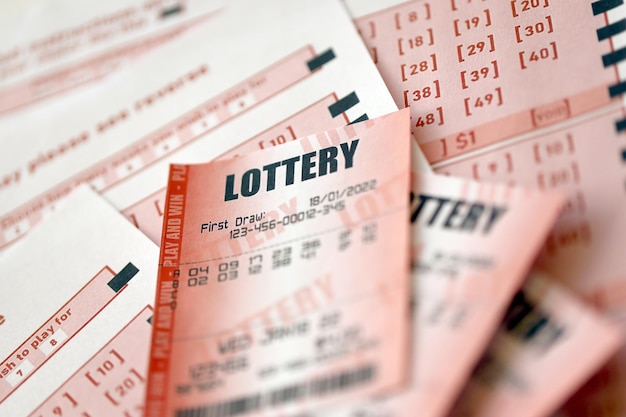Le billet de loterie rouge se trouve sur des feuilles de jeu roses avec des numéros pour marquer pour jouer à la loterie Concept de jeu de loterie ou dépendance au jeu Gros plan