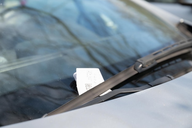 Billet de stationnement sous l'essuie-glace de pare-brise voiture stationnée illégalement payer violation de la circulation