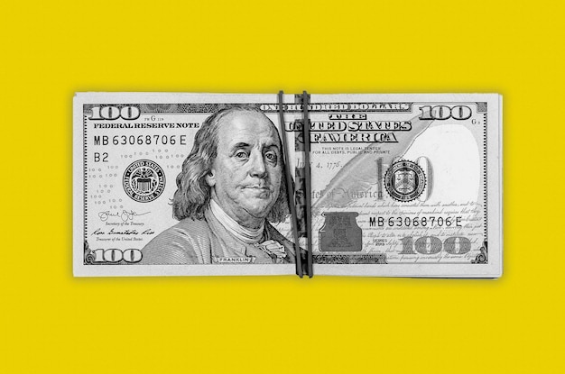 Billets de banque en dollars gris sur fond jaune