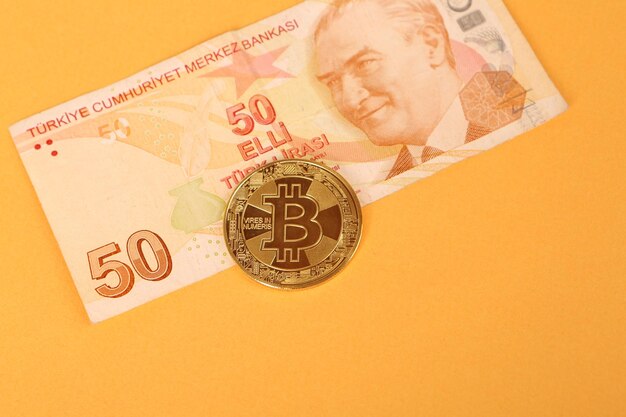 Billets de banque en lire turque et pièce de monnaie bitcoin