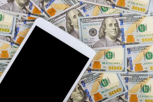 Billets de cent dollars américains sur tablette numérique