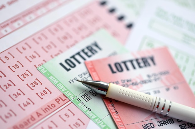 Des billets de loterie verts et rouges avec un stylo sur des billets blancs avec des numéros pour jouer à la loterie