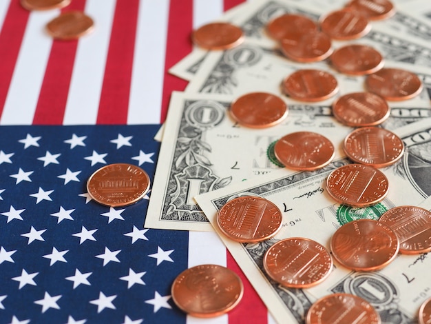 Billets et pièces en dollars et drapeau des États-Unis