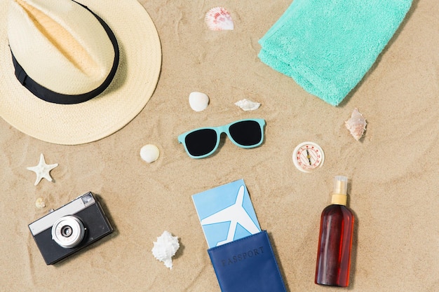 billets de voyage caméra et chapeau sur le sable de plage