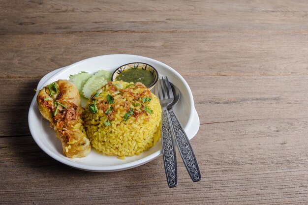 Biryani de poulet avec du jasmin cuit sur fond de bois