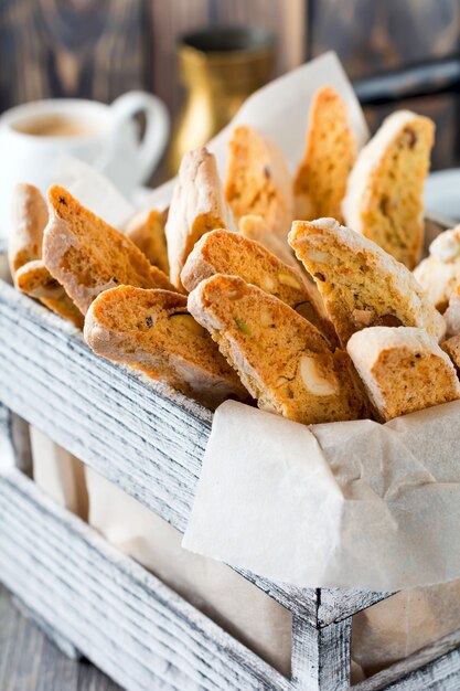 Biscotti maison aux noix dans une boîte en bois sur le vieux fond en bois. Mise au point sélective.