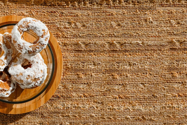 Biscuit au beurre avec du sucre glace sur le dessus dans un récipient en verre transparent. Lumière dure avec des ombres nettes. Vue de dessus. Mise au point sélective.