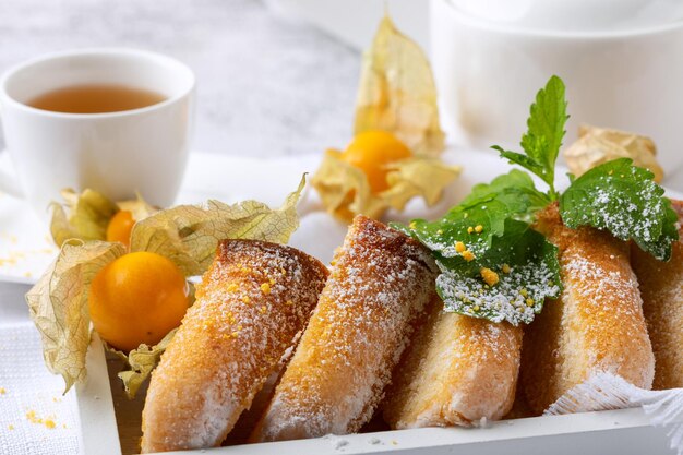 biscuit au citron sur un plat blanc sur fond blanc avec des baies de physalis